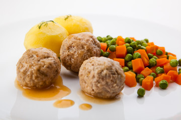 Roasted meatballs with boiled potatoes, peas and carrot
