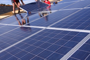ouvriers sur un toit installant des panneaux solaires