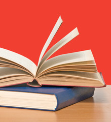 Open book on desk  on red background