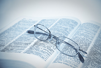 closeup of opened book and glasses