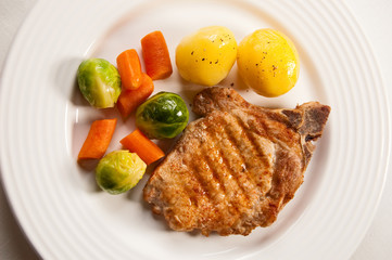 Grilled meat with boiled potatoes and vegetable salad