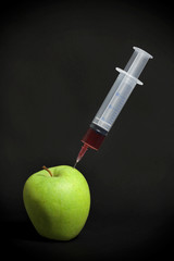 Syringe in green apple