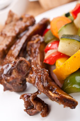 barbecue spare ribs on a plate with vegetables