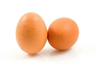 Two chicken eggs over white background