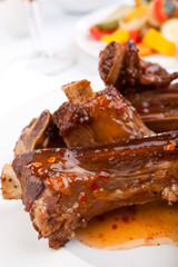 barbecue spare ribs on a plate with vegetables