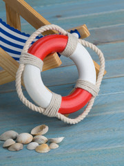 Maritime Dekoration mit Rettungsring und Liegestuhl - Urlaub an der Küste