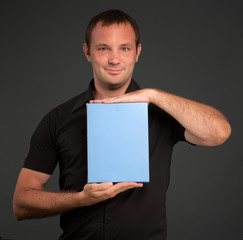 Man in black showing a blank package