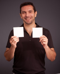 Cheerful man holding two blank cards