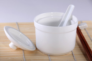 Close-up of  bowl with soup spoon; chopsticks at the right