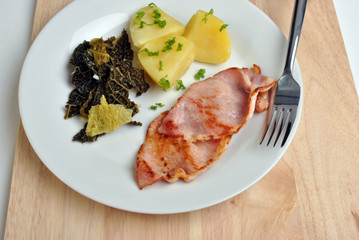 bacon, cabbage and mashed potato on a plate