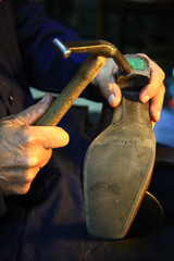 Zapatero con martillo y zapato