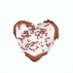 Heart shaped cookie with white frosting on white background