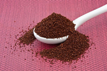 Ground coffee in a White Spoon