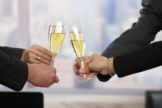 Business people raising toast with champagne
