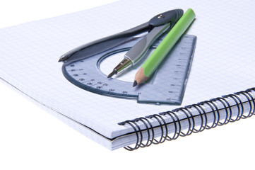 Compasses, protractor and pencil on copybook