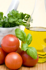 tomatoes, basil, parsley and bottle of olive oil