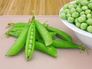 Pods sweet green peas and beans on a plate close-up