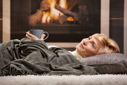 Woman resting beside fireplace