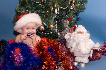 Cute Baby in red hat in front of Christmas Tree