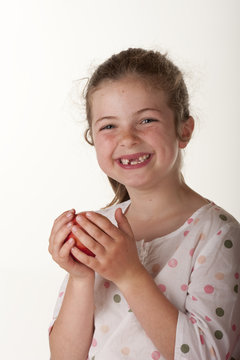 little girl eating red apple