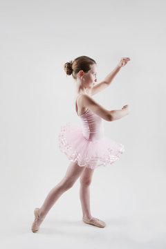 little girl practicing ballet in pink tutu