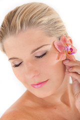 Young healthy woman with beautiful pure skin and flower