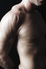 Fototapeta na wymiar Muscular male torso on black background