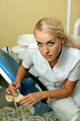 Beautiful dentist working with materials in medical office