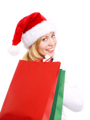 smiling woman in christmas clothes holding shopping bags over wh