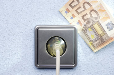 silver  socket on a blue wall with money