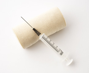 Fototapeta na wymiar Syringe and bandage on white background