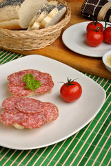 slice poppy seed bread with salami on a plate