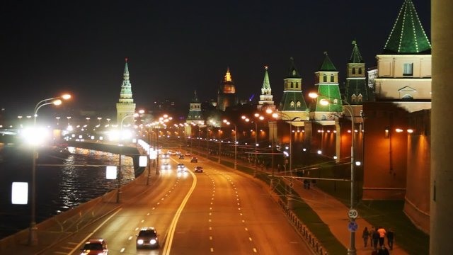 Cars go on road along the river and Kremlin towers in Moscow