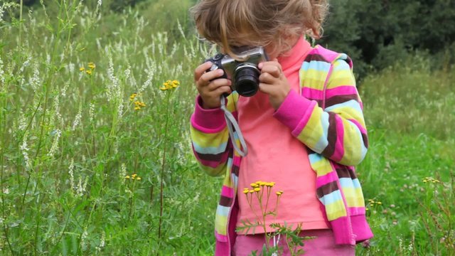 little girl with photo camera outdoor