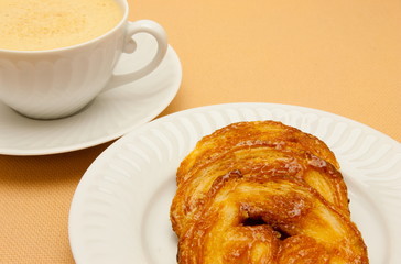 Closeup of coffee with milk in white cup and a palmier pastry