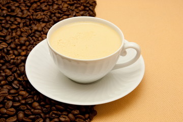 White cup of coffee and coffee beans