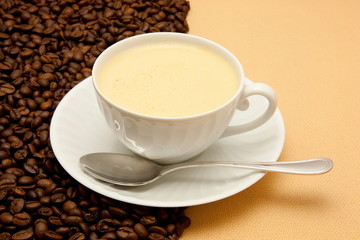 White cup of coffee and coffee beans