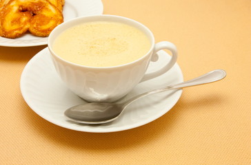 Closeup of coffee with milk in white cup and a palmier pastry