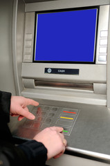 Cash withdrawal. Woman's hand entering pin on ATM