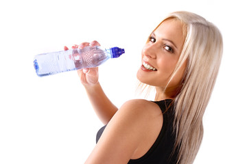 Woman in fitness attire holding water bottle and smiling