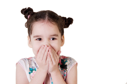 Laughing little girl covering her mouth with her hands