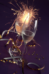 Champagnerglaeser auf lila Untergrund mit Tischfeuerwerk