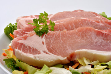 some raw organic pork chop and parsley