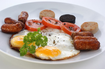 irish breakfast on a white plate with tomato