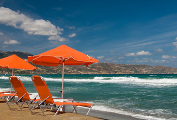 Orange beachchairs with umbrellas