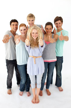 Group of teenagers standing in front of the camera with thumbs u