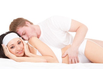 Young happy couple lying on the white bed