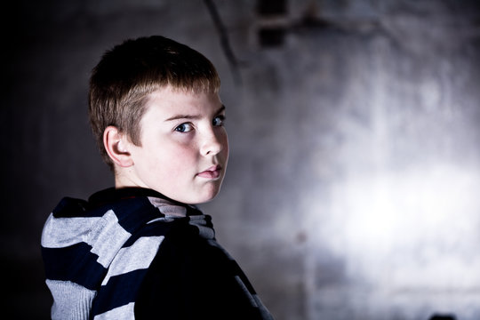Boy looking over the shoulder grunge background lit with flash