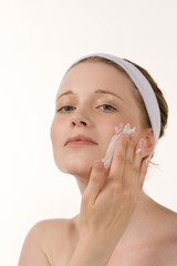 Frau cremt Gesicht ein, Wellness,
