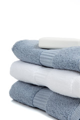 Gray blue and white towels with soap on white with copy space